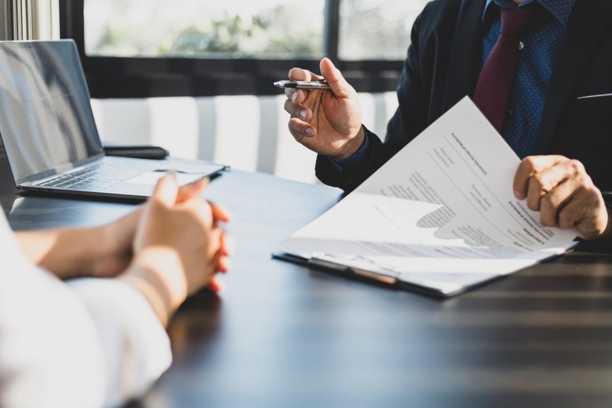 two people discussing telluride property management at a desk with a contract